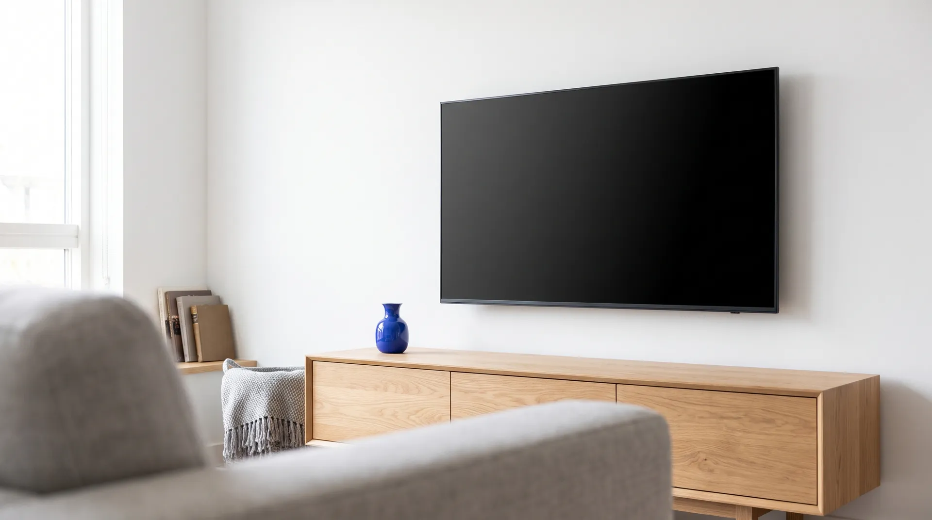 Large TV mounted level at seated eye level above an oak media console