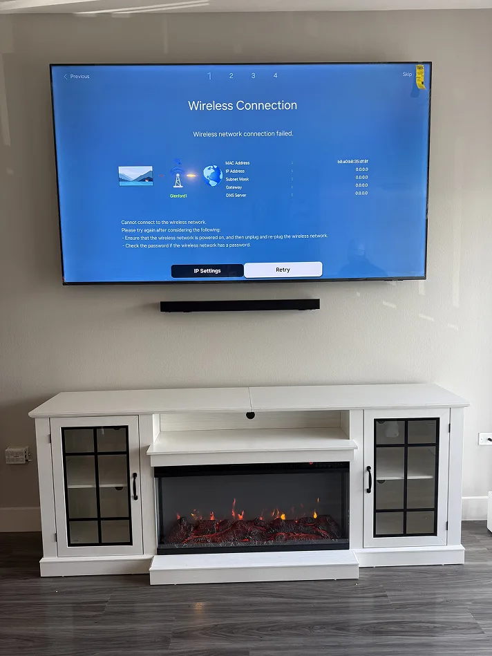TV and soundbar mounted above a white electric fireplace console