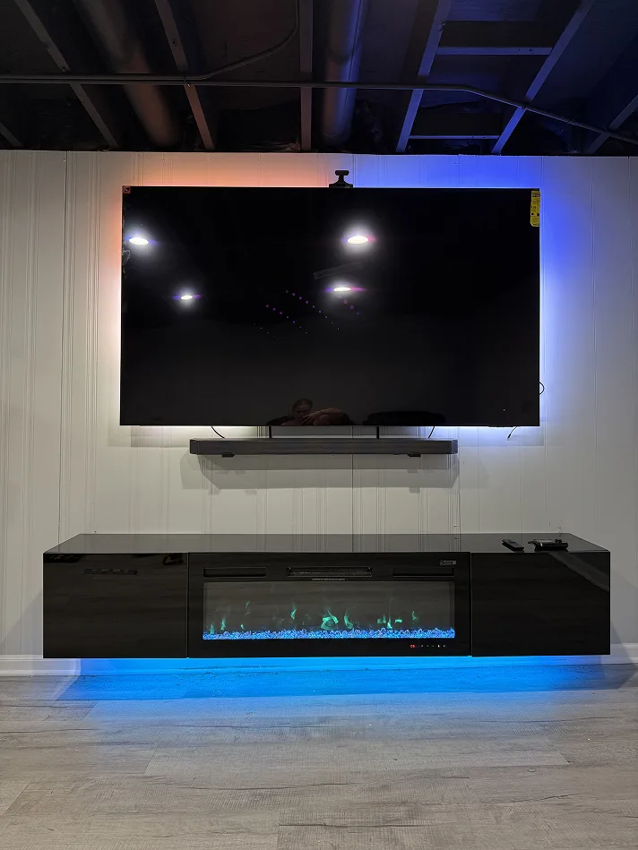 TV and soundbar above a black floating fireplace console with LED lighting