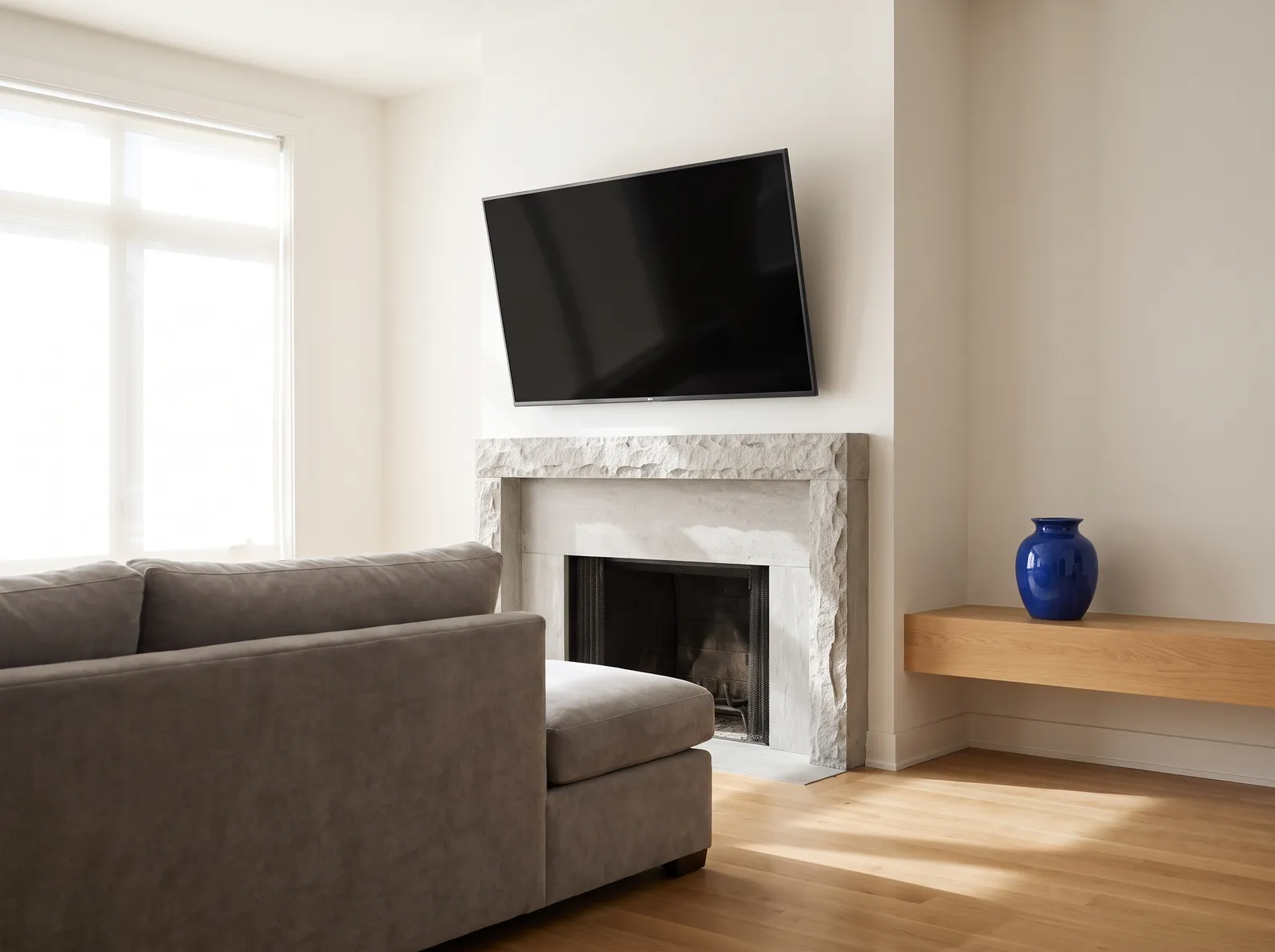 TV on a tilting mount above a stone fireplace angled toward the sofa