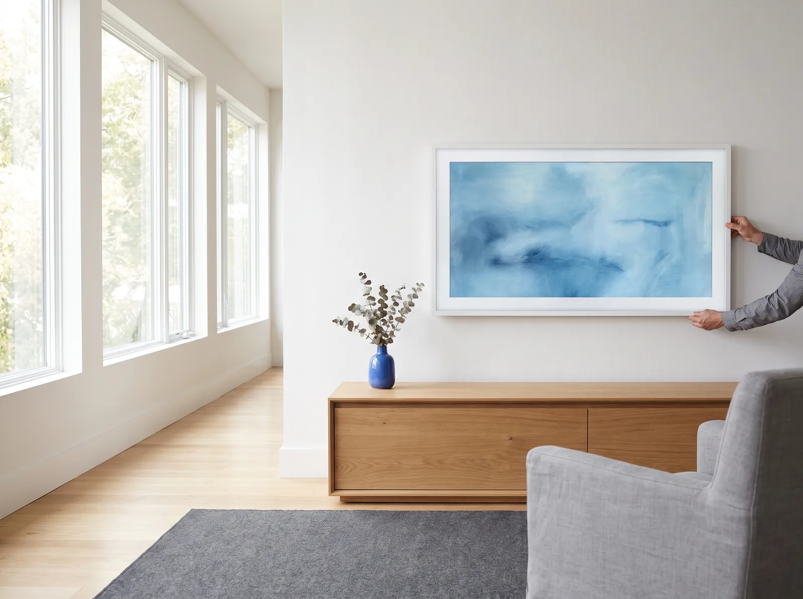 Installer hanging an art-style TV flat against the wall like a framed picture